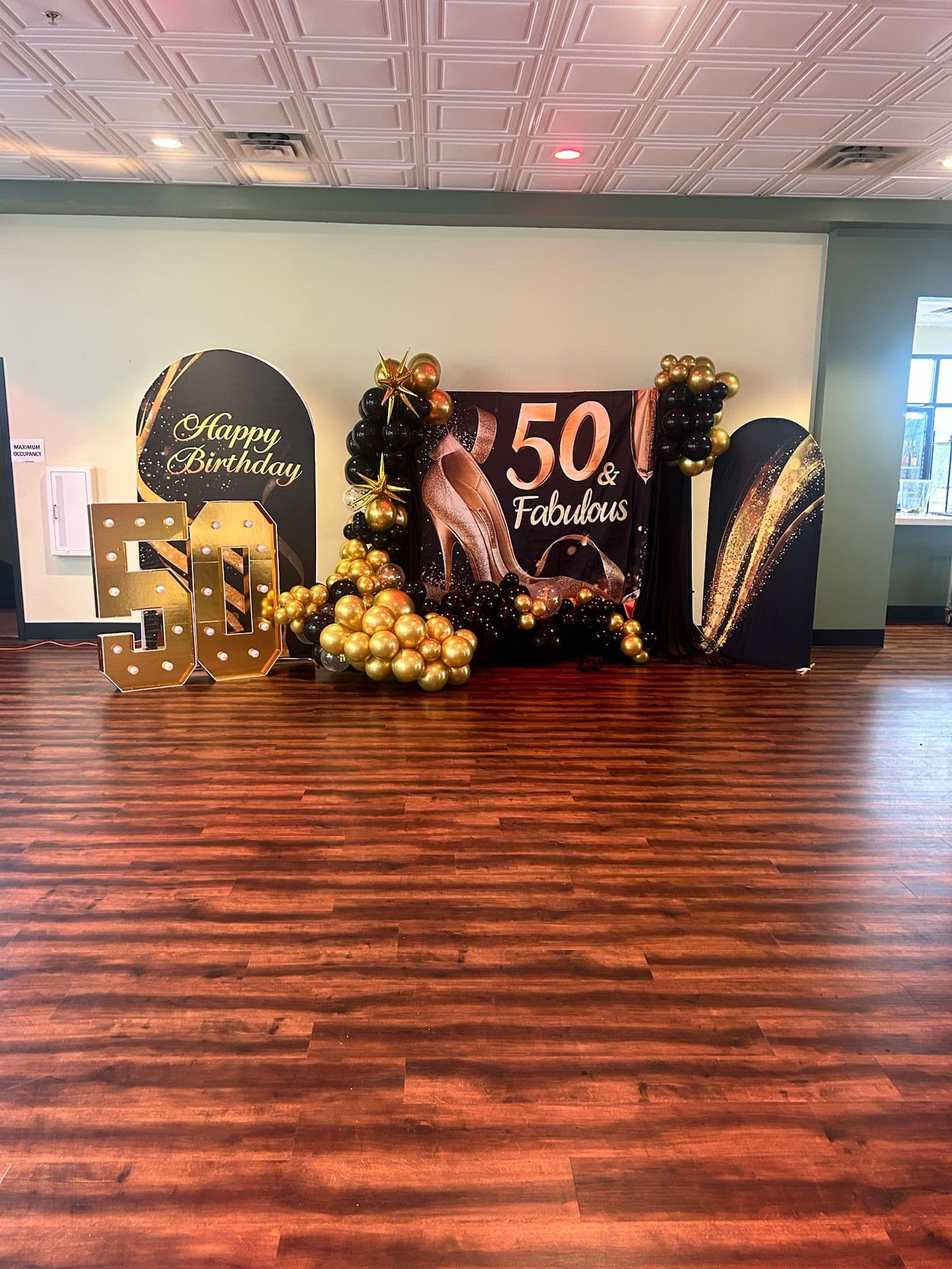 50th birthday backdrop with gold balloons in an event room at BB's Events