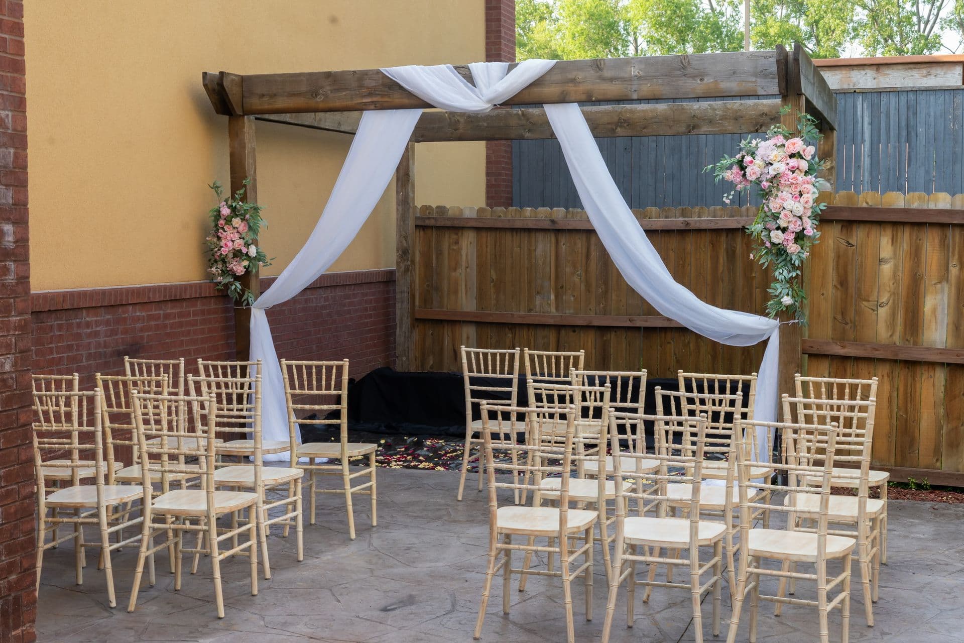 Garden Patio with draped arbor and chiavari chairs for an intimate ceremony