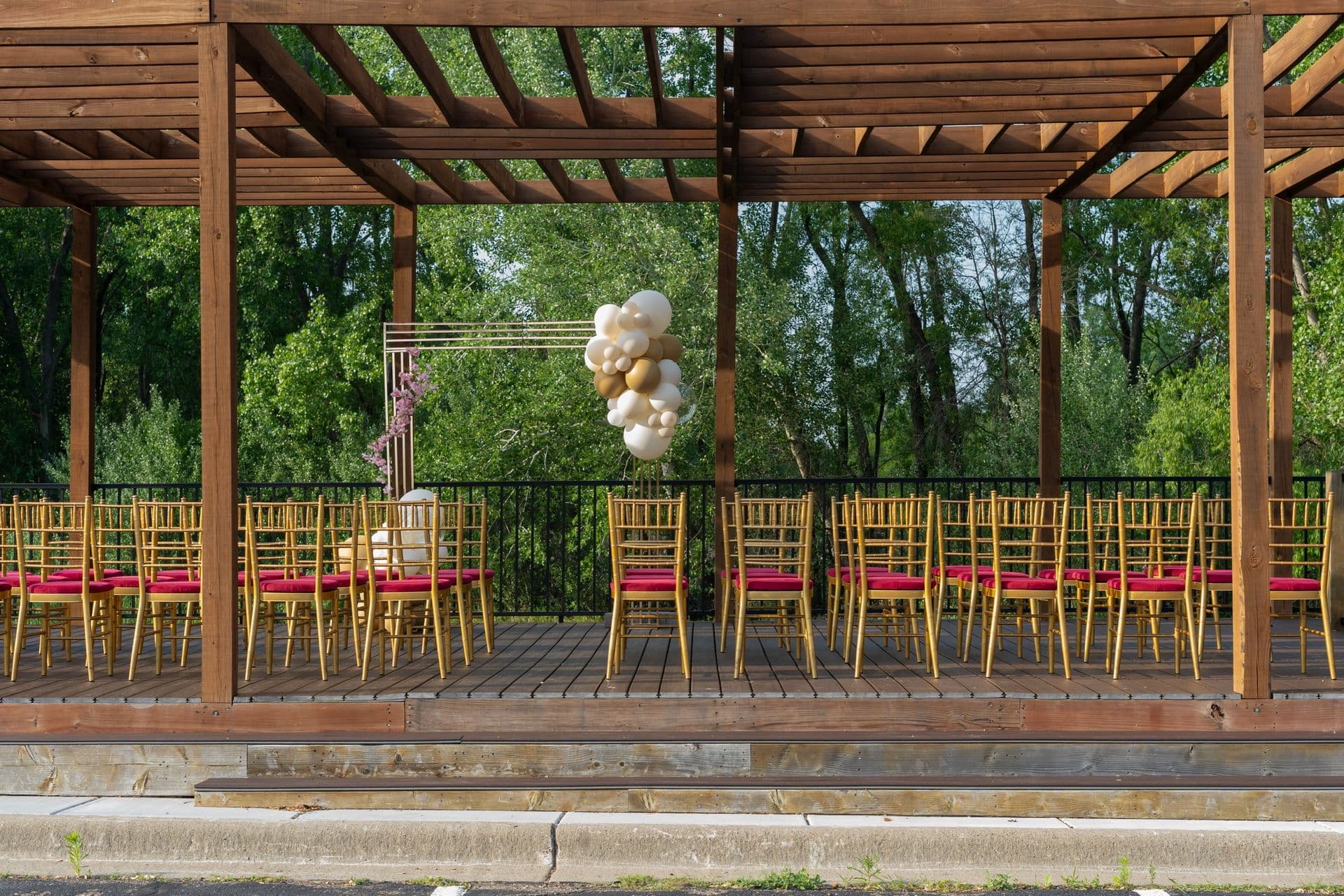 The Pergola outdoor event space set with rows of gold chairs