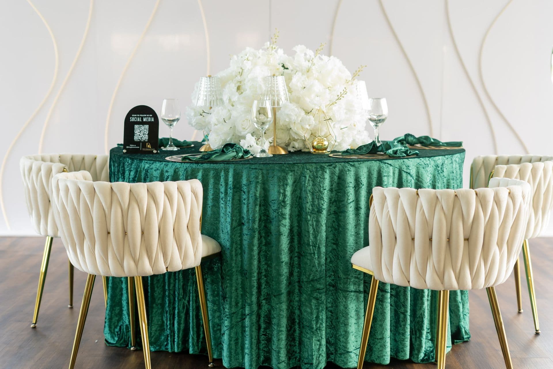 Private dining table with green velvet linen, white florals and cream chairs