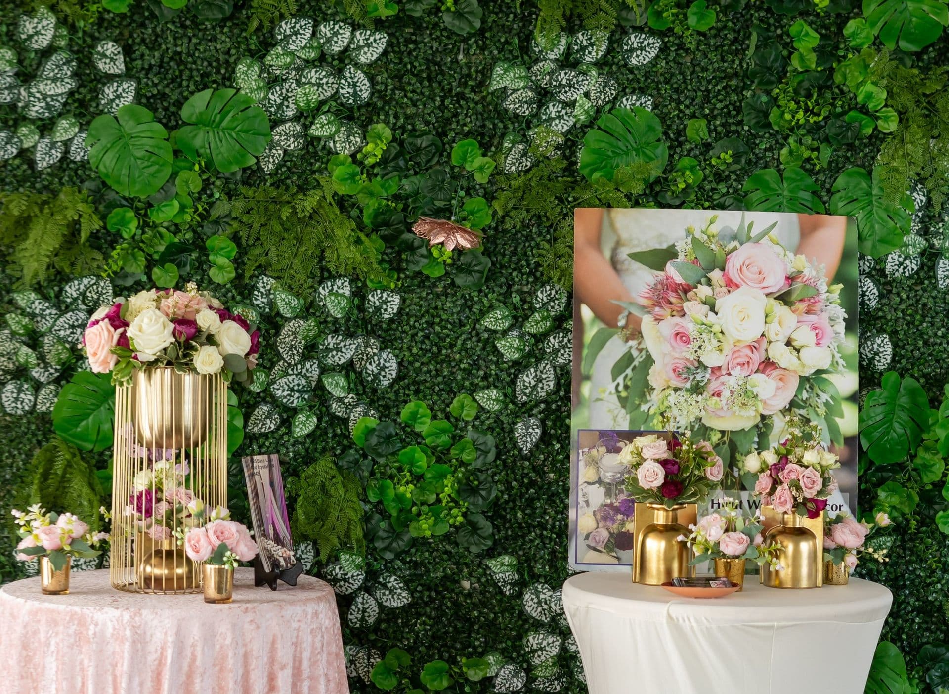 Living greenery wall with pink floral arrangements set up for a shower